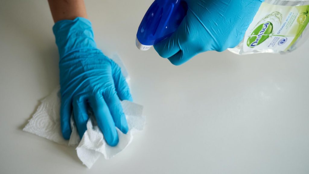 Eine Person mit Handschuhen, die Reinigungsarbeiten durchführt.
